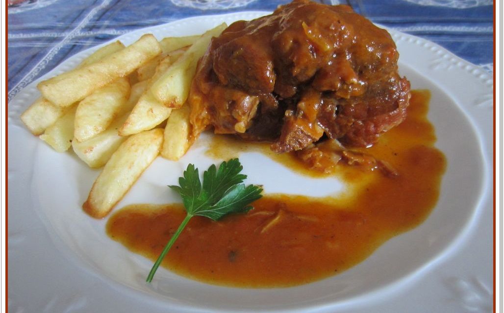 Codillo de cerdo en salsa, guisado en olla rápida, con patatas gajo asadas